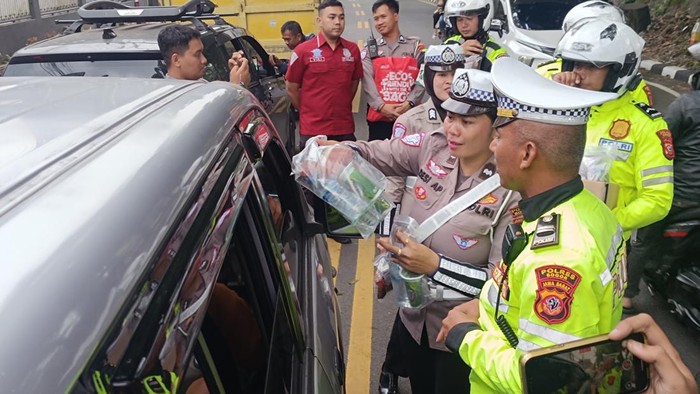 Polisi Serahkan Makanan ke Ratusan Pengendara Tersesak di One Way Puncak
